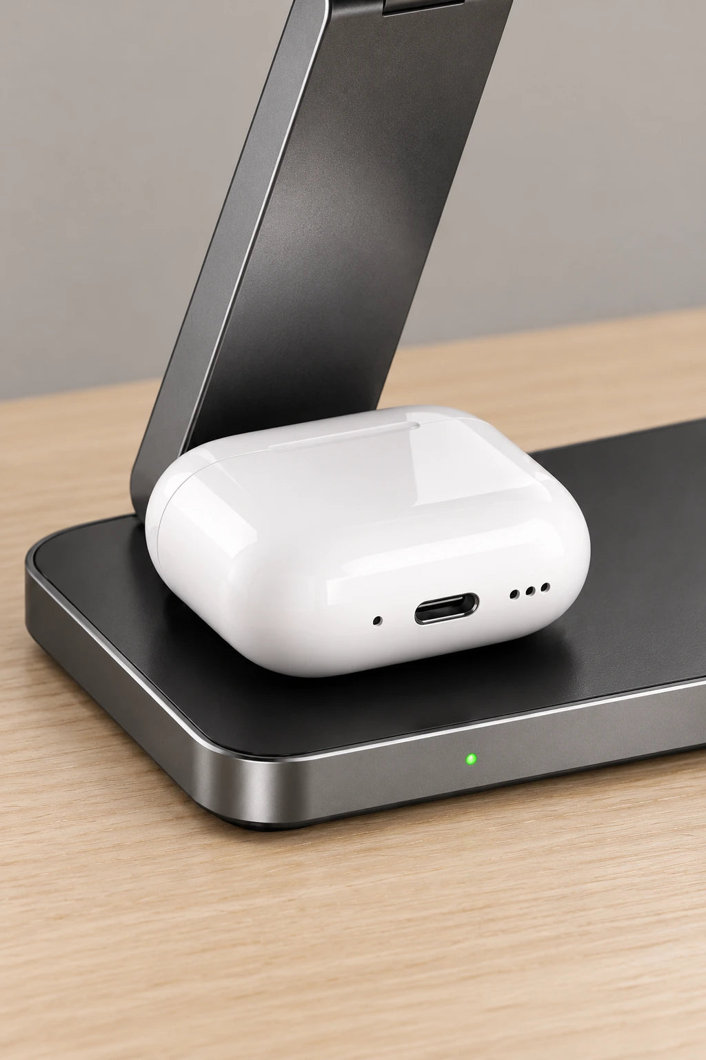 White earbud case on the left pad beneath the folding arm of a gray charging base.